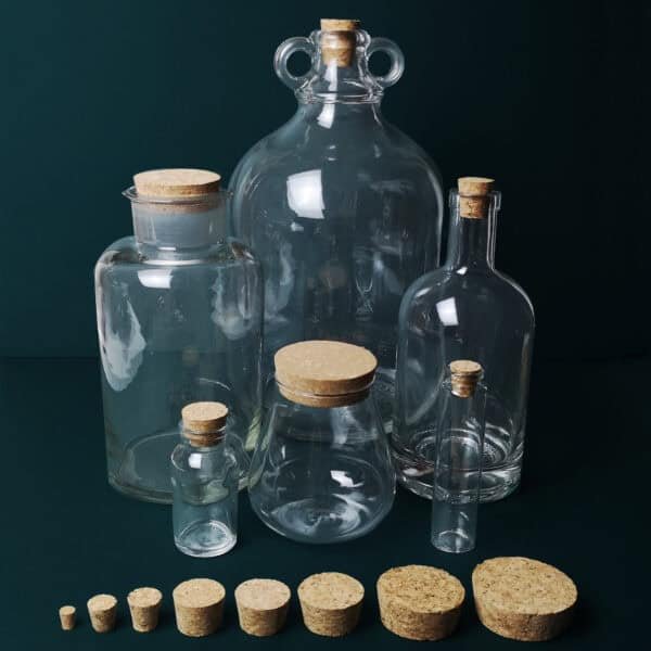 Clear glass bottles with cork stoppers, ideal for storage or decorative use.