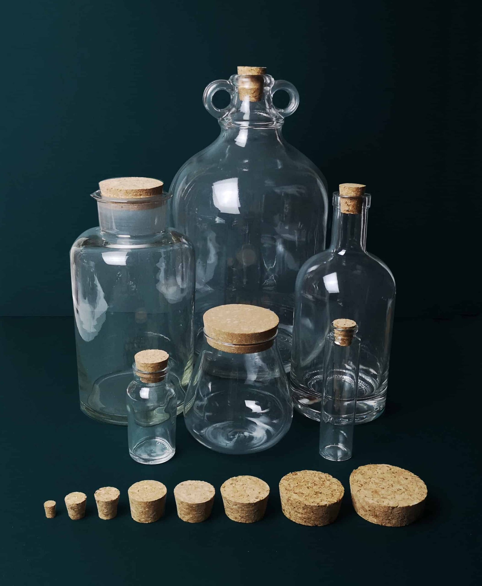 Clear glass bottles with cork stoppers, ideal for storage or decorative use.